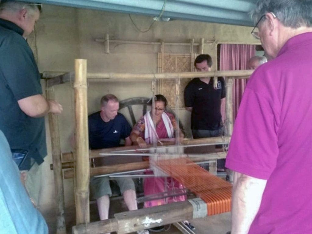 Turistas visitando el telar manual para ver cómo se tejían los productos.