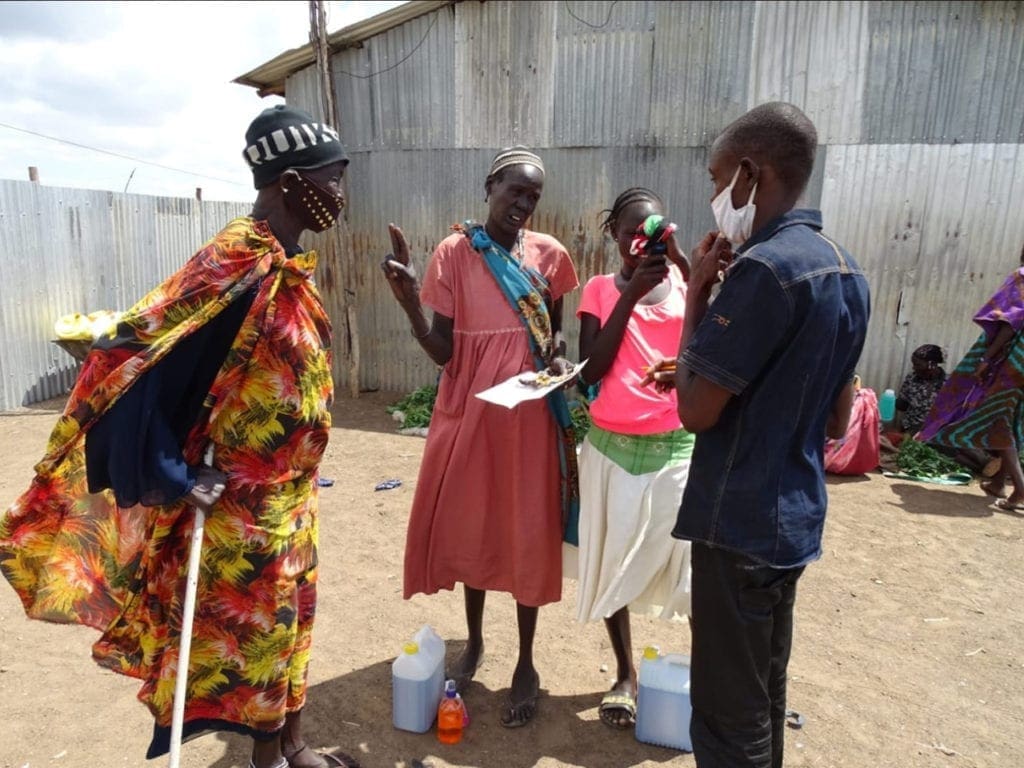 Inocente Haviyarimana junto con un grupo de aldeanos repartiendo jabón.
