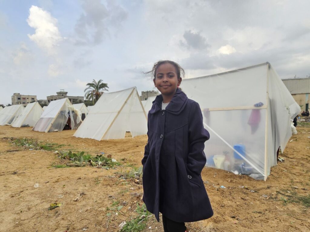 Nine-year-old Lama stands at a refugee camp after being displaced from her home in Gaza City following Israel's counteroffensive. | Photo courtesy Lama Abu Jamous