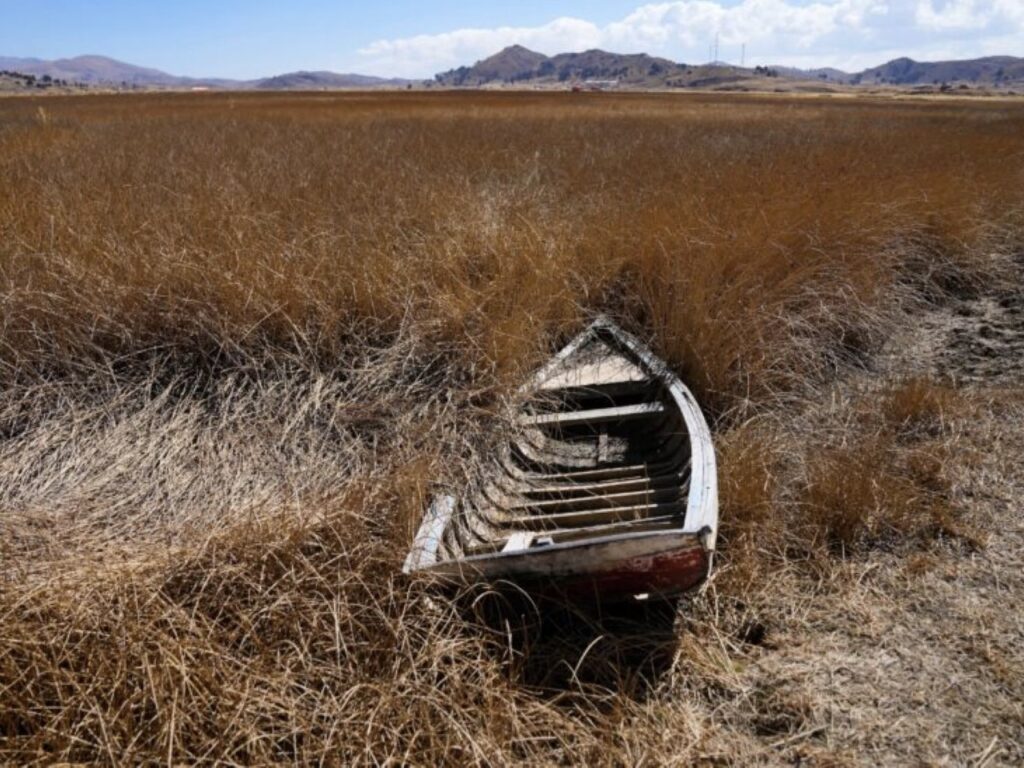 An abandoned boat sits in a dried out area of Lake Titicaca