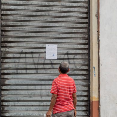 Man reads a notice posted in a vendor error where workers were evicted in San Salvador