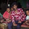 A "ragpicker" named Ashok sits inside his house with his five children in Nilothi, New Delhi