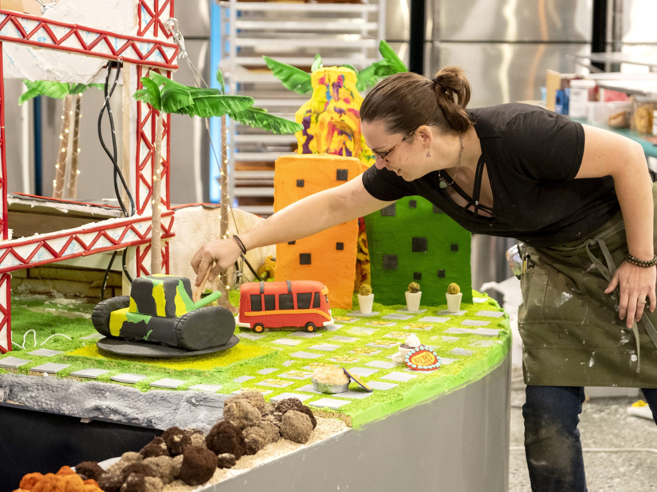 Schonour puts final touches on her team's grand finale creation. The massive bake/build had to include an edible bridge that moves to allow a boat to travel under it, could withstand a car being driven over it, and could hold up to 250 pounds of weight