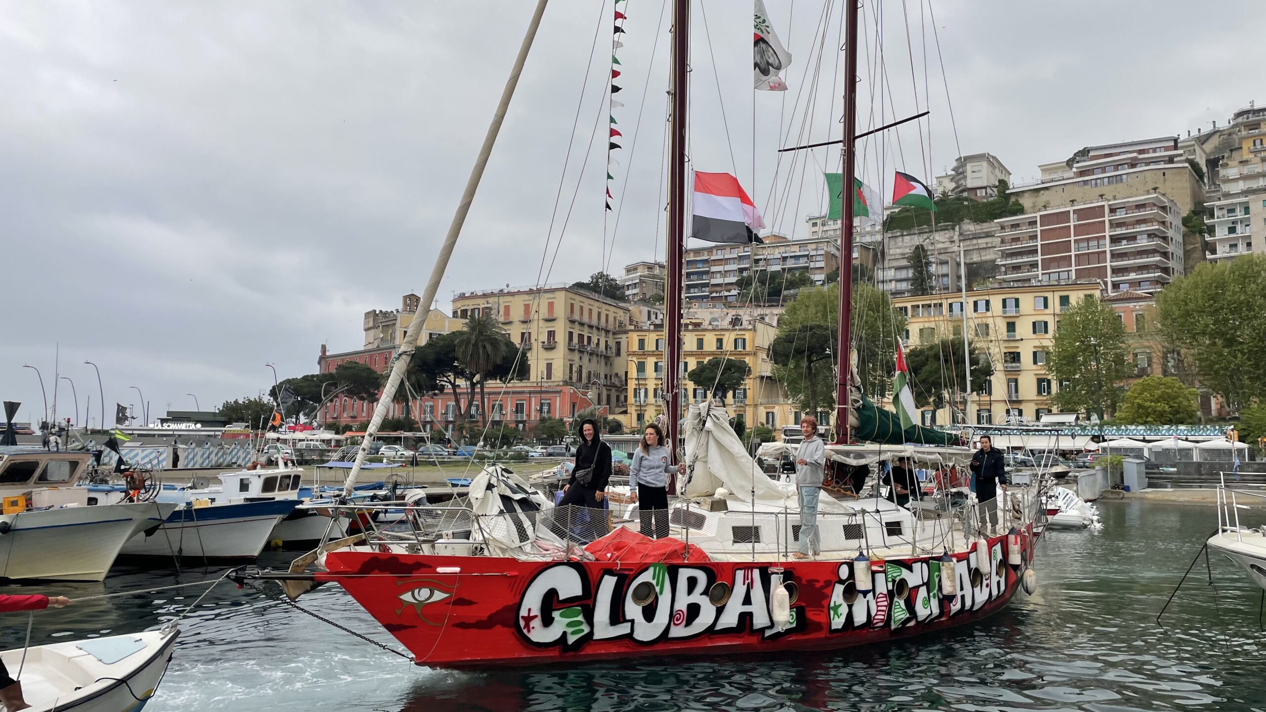 Flotilla sailboat displaying Palestinian flags while sailing at sea