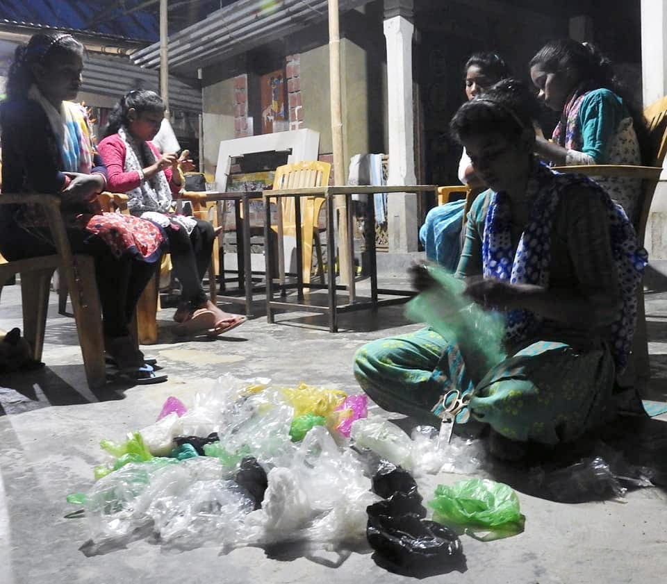 Mujeres cortando bolsas de plástico con tijeras.