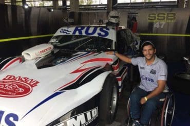 Juan poses with his adapted Chevrolet racing car, which he can drive entirely by controls located at the wheel