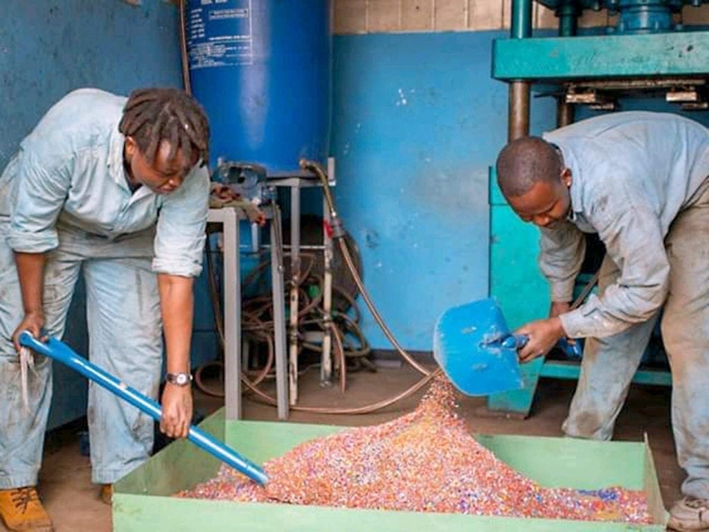 Engineers shovel plastic waste during the recycling process.