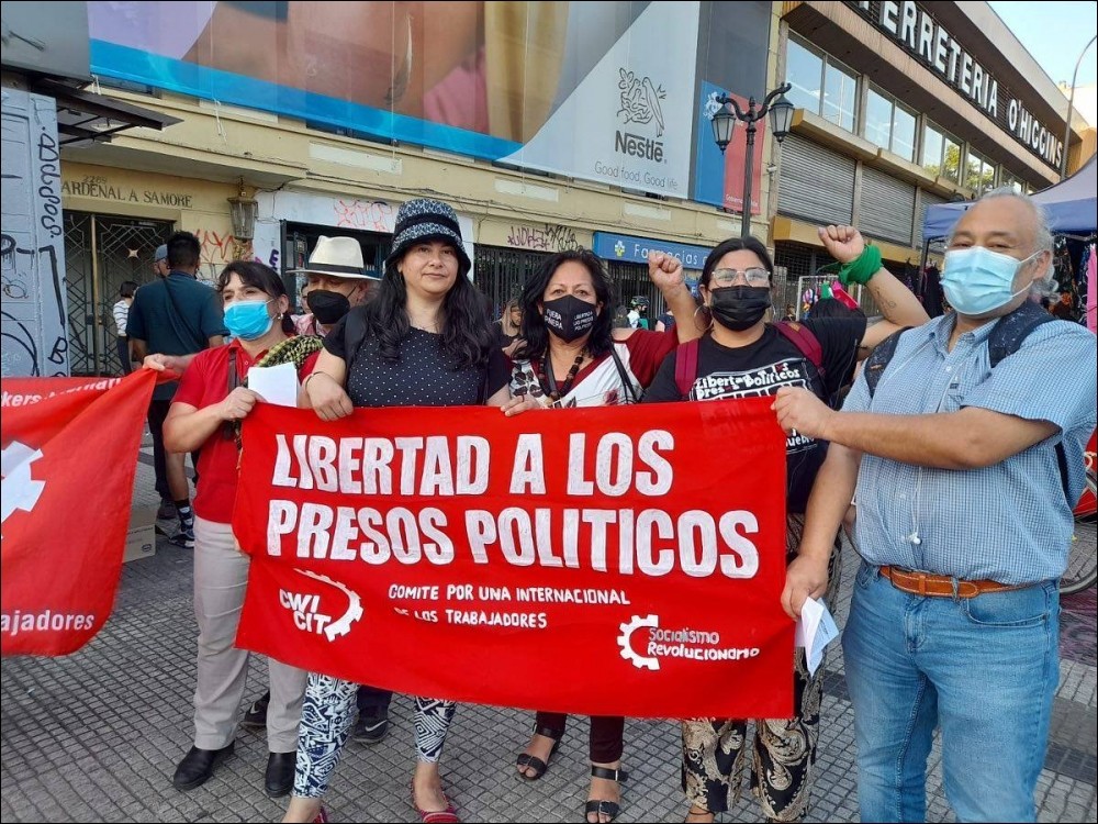 People holding a banner calling for the release of political prisoners during a protest in Chile.