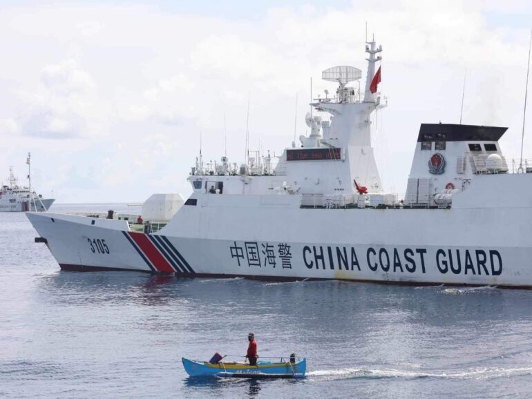 Photojournalist captures iconic image of Filipino fishing boat eclipsed by Chinese Coast Guard vessel at the disputed Scarborough Shoal