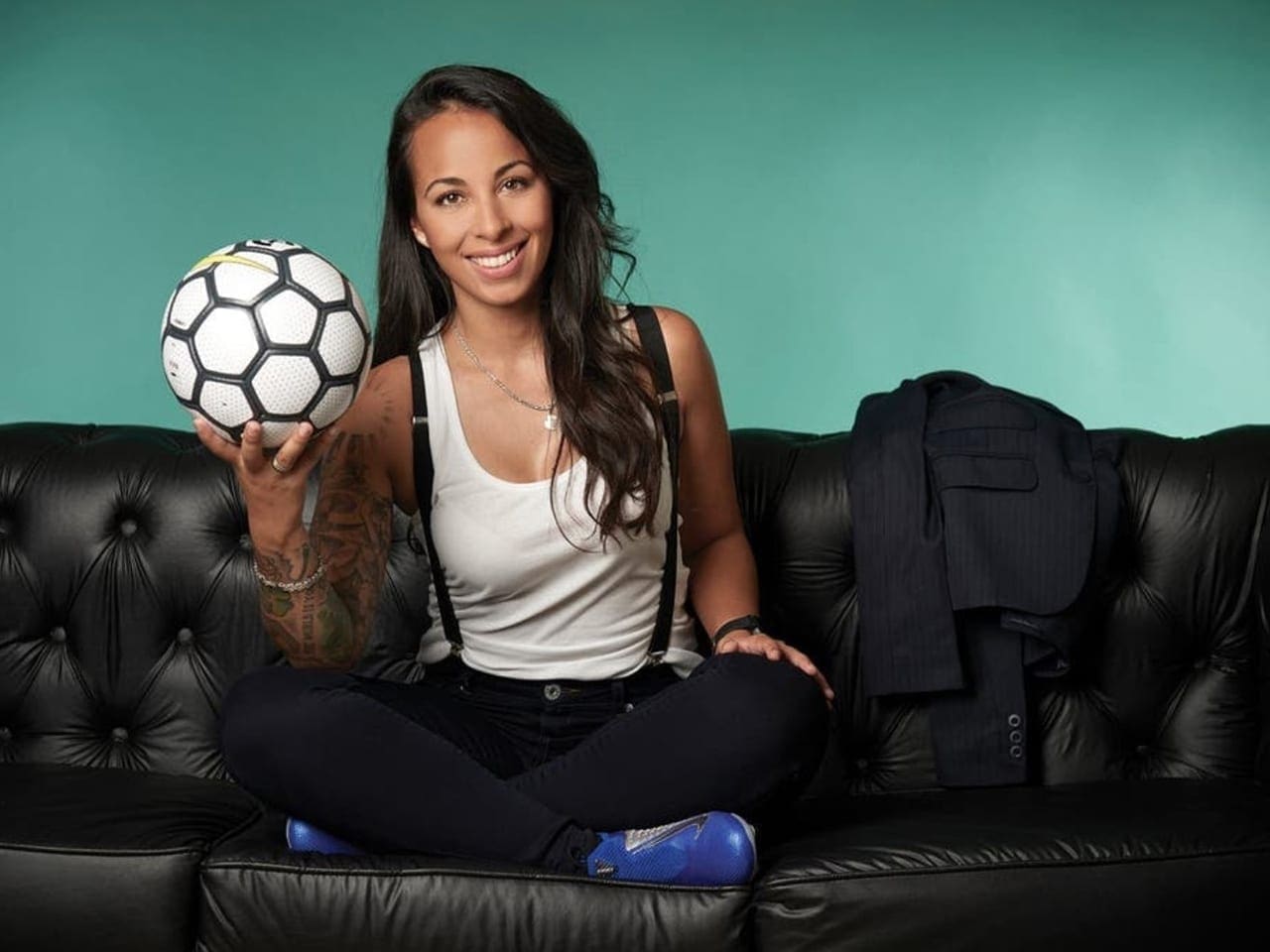 Evelina Cabrera, sits in a portrait with a soccer ball.