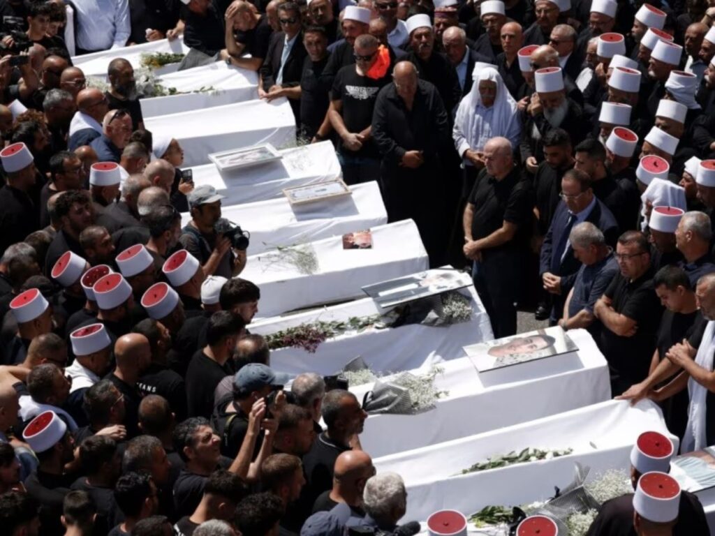 Druze elders and mourners surround the coffins of children killed in a rocket strike on July 27, 2024, during a mass funeral in the Druze town of Majdal Shams, Israel. | Photo courtesy of 