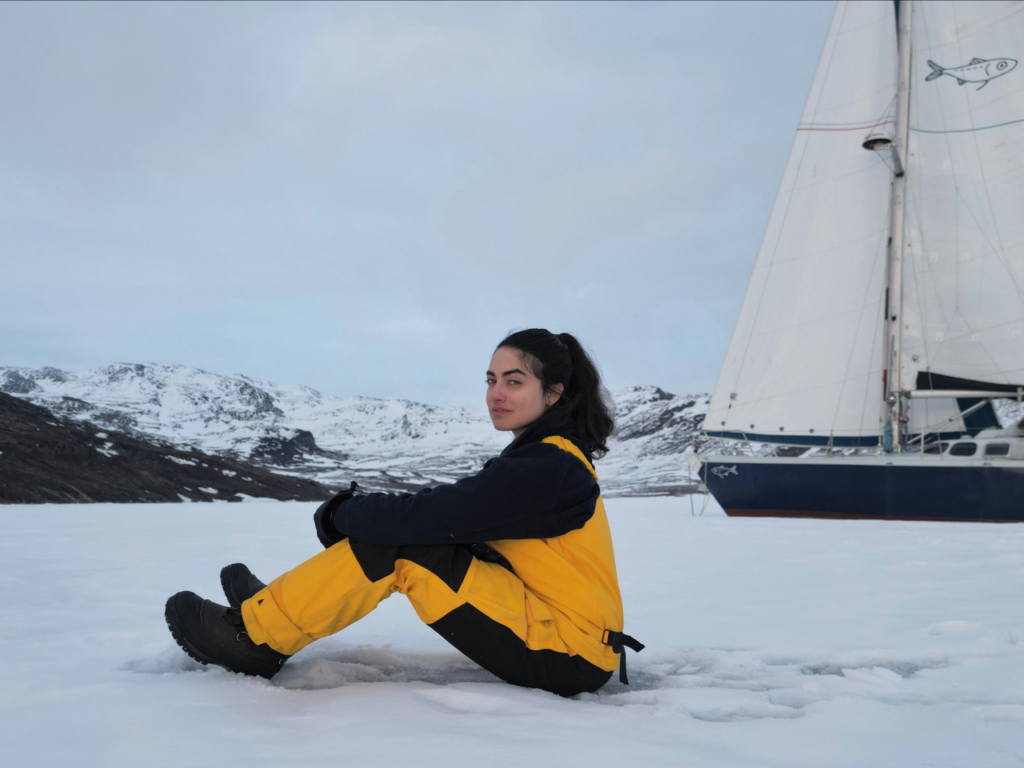 Tamara seated on the snow, gazing at the Arctic environment. | Photo courtesy of Tamara Klink.