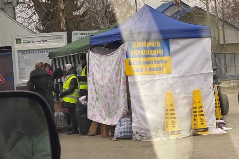 A food service tent in Romania. The sign reads "Help for Ukrainians, Free food & drink"