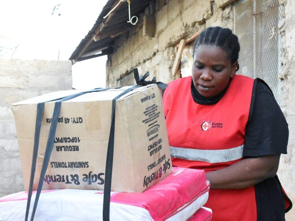 Milka Hadida prepares her load on her bicycle to distribute sanitary pads