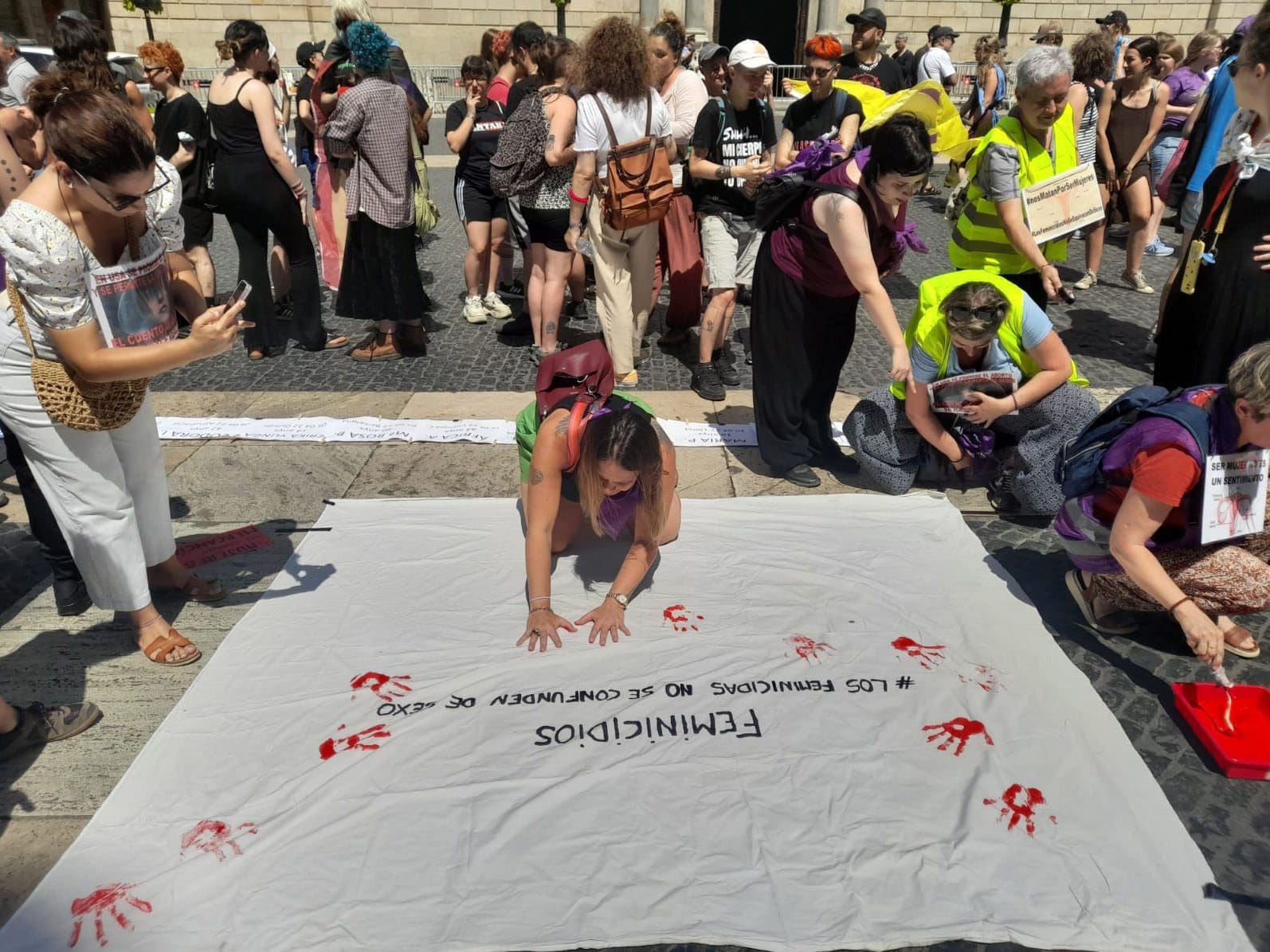 Women gathered on the streets leaving handprints on the banner "No Feminicidios" (Say no to murdering women )