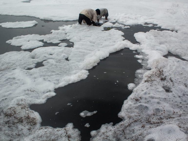 Divers take a plunge in New Delhi’s toxic foam-covered river to make livelihood