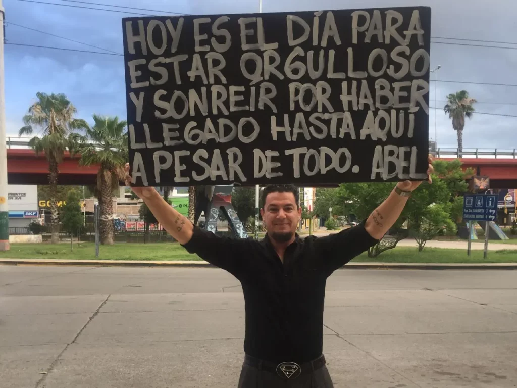 After plunging into a terrible depression, Abel Trillini is finally working towards healing himself. He holds motivational signs each morning outside his home city in order to cheer up strangers passing by.