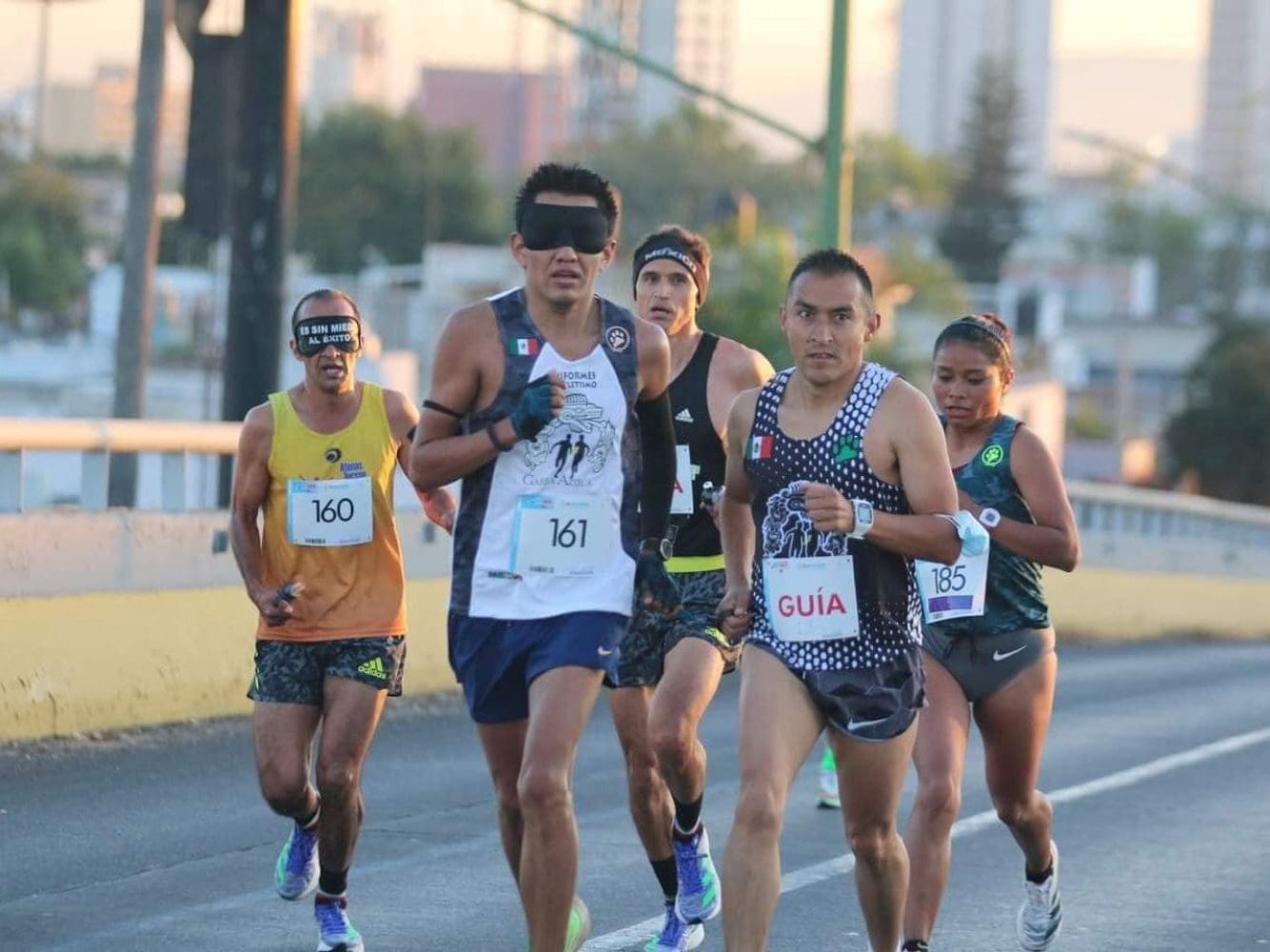 David Juárez runs in a race with the help of a guide