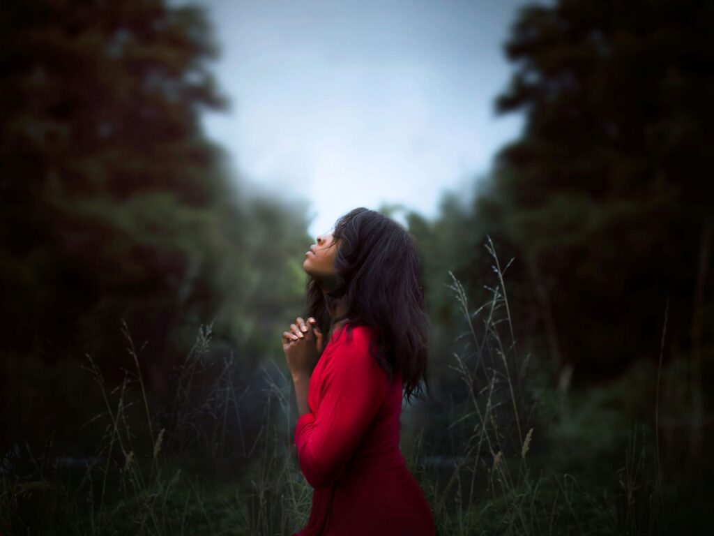 A woman prays. | Photo courtesy of Diana Simumpande on Unplash