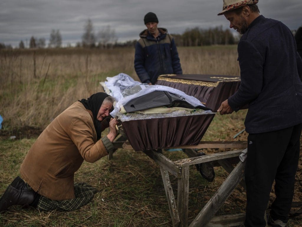 Nadiya Trubchaninova, 70, weeps as she kneels next to the coffin containing the remains of her 48-year-old son during his funeral at the Mykulychi cemetery, on the outskirts of Kiev, Ukraine, on April 16, 2022.