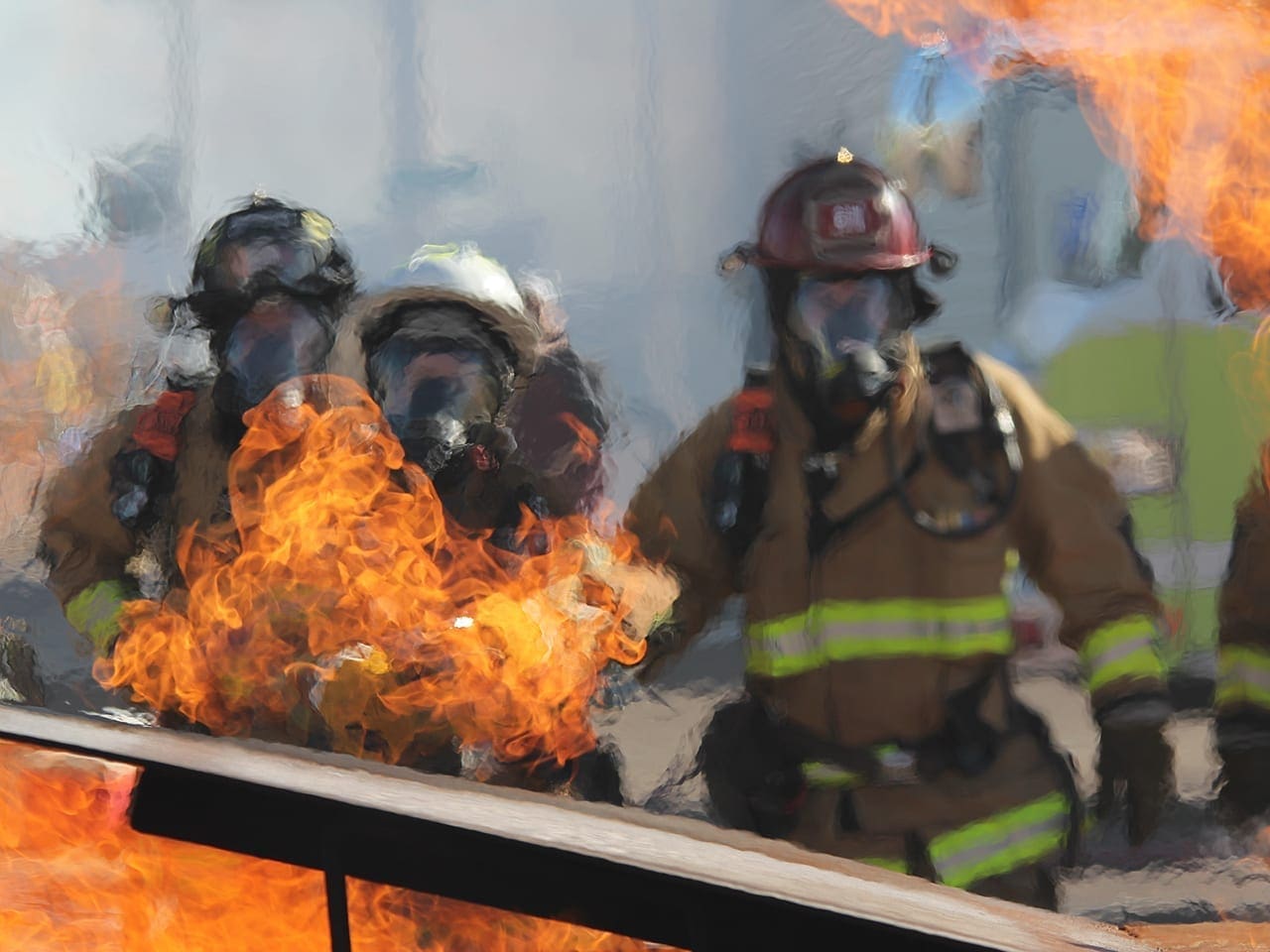Firefighters stand before a blaze in this stock photograph.